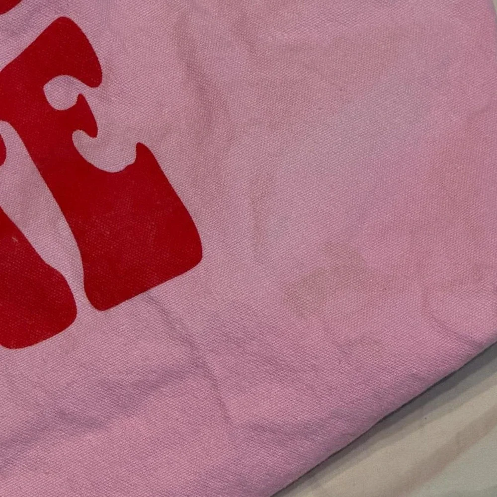 Pink tote bag with red text